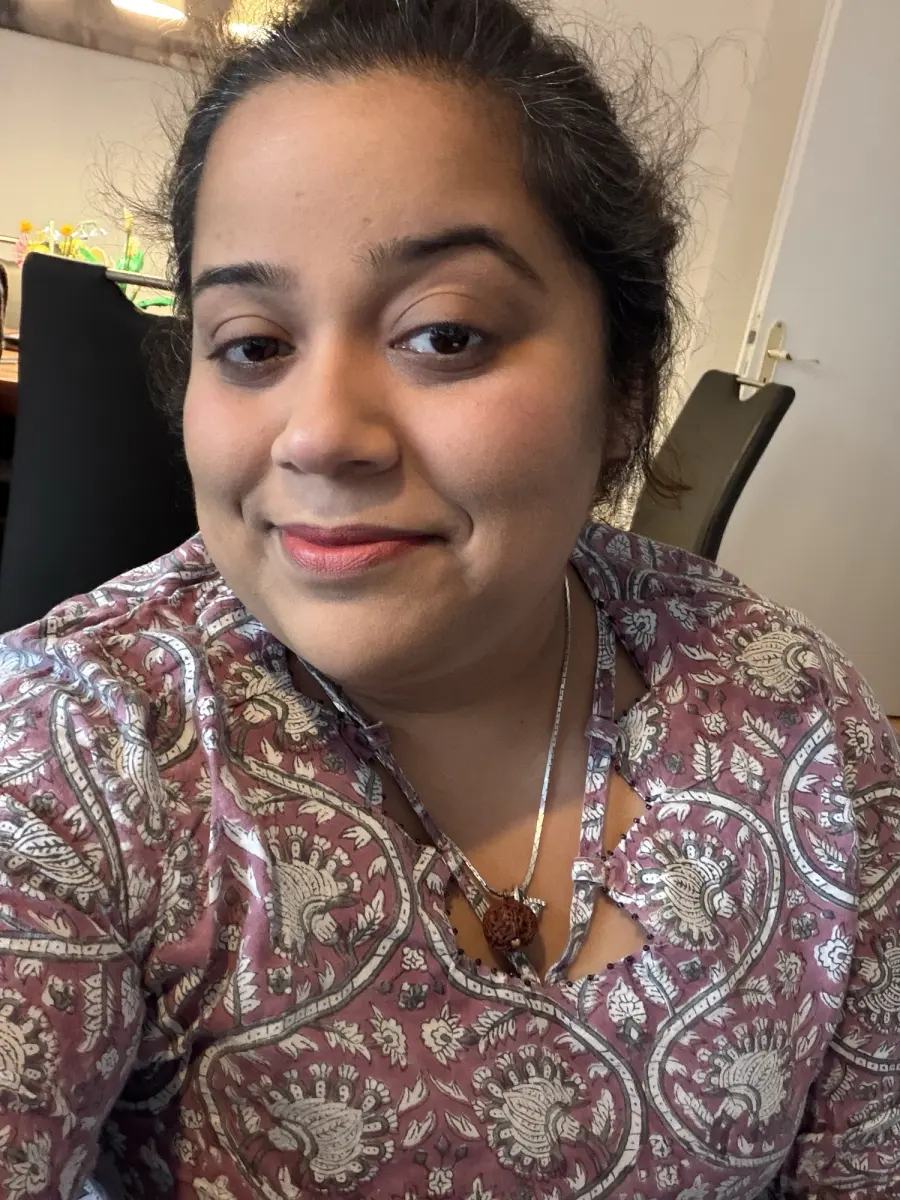 Priya at home in a patterned kurta, smiling